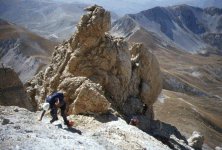 Uno dei tanti -massi- lungo la Via Direttissima. 
In secondo piano, il Sassone di quota 2600 mt. e,
sullo sfondo, Campo Imperatore e la dorsale sud
della catena del Gran Sasso.
(11613 bytes)